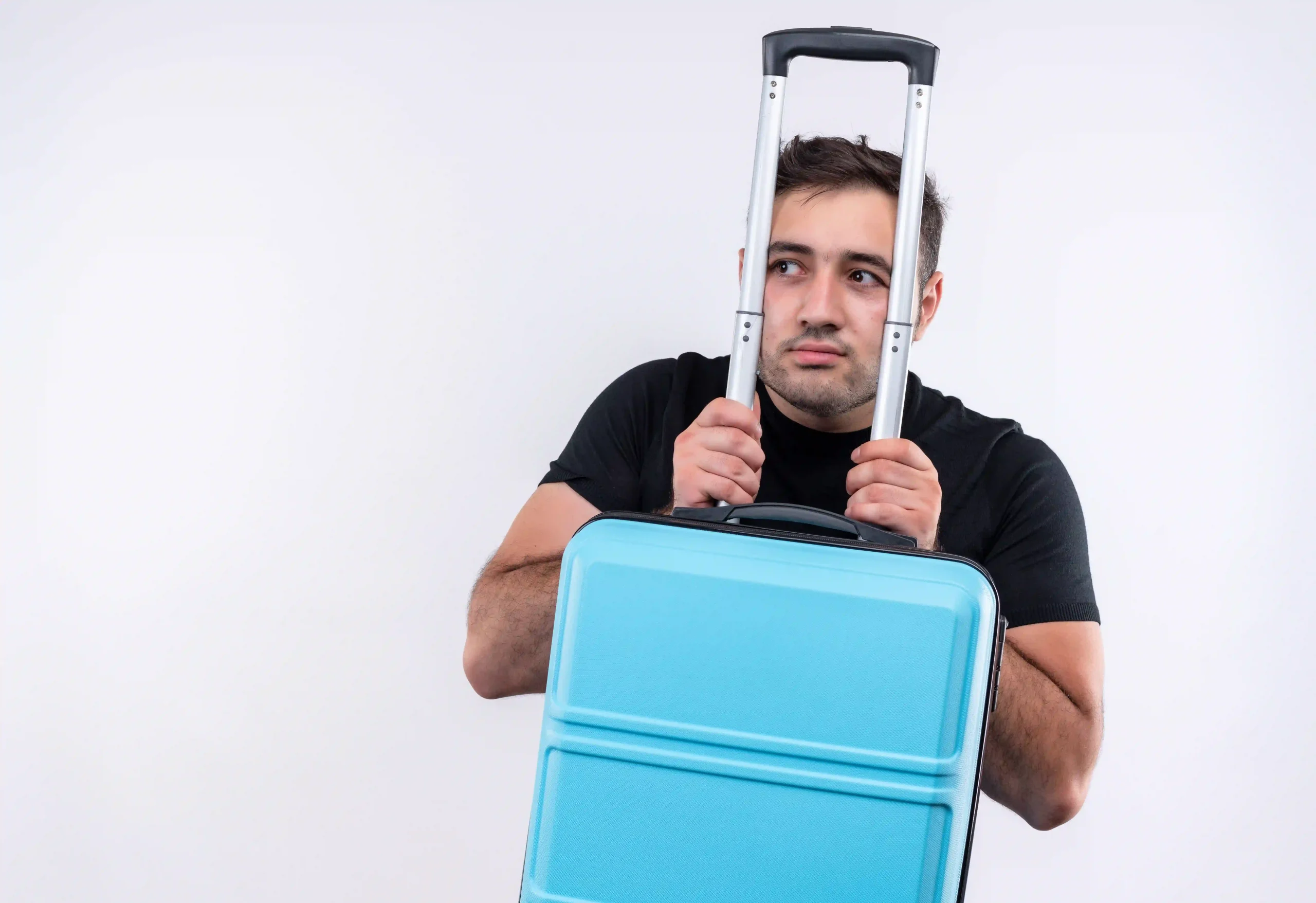 1.young-traveler-man-black-t-shirt-holding-suitcase-looking-aside-worried-with-fear-expression-standing-white-wall