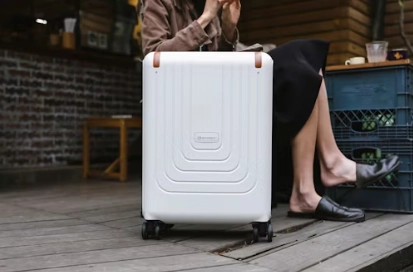 a woman next to a white luggage