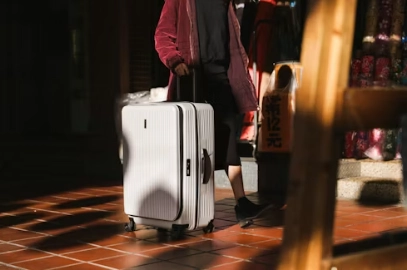 a man holding a white luggage